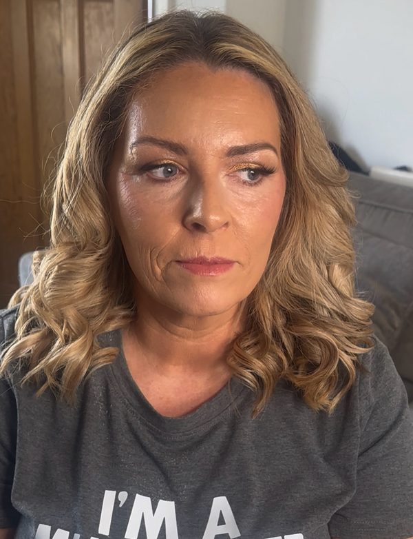 Full glam make-up on a client with shoulder-length wavy blonde hair: blended bronze and brown eyeshadow, defined brows and a soft nude-pink lip.