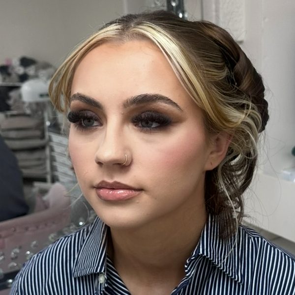 Full glam make-up on a client with a braided blonde updo: warm bronze smoky eyes, strip lashes and a soft pink lip.